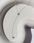 925 Sterling Silver Green opal lariat laid on a white plate in the sunlight. This necklace features our simple chain connected by the Green opal gemstone dangling on the lariat is another green opal lariat.