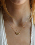 Model wearing 14k gold fill Sunrise Necklace - Token Jewelry - hand cut 14k gold fill or sterling silver sheet metal - half circle sunrise horizon shape - hanging from chain - locally handmade in our Eau Claire, WI studio - Token Jewelry