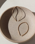 14k gold fill petals set on a gray plate in the sunlight. These earring feature a slide type earring great for everyday.