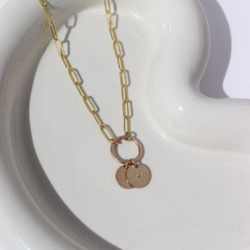 A textured chain-link style 14k gold fill necklace chain featuring a gold hoop, from which hangs two stamped discs