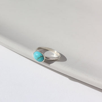 Sterling Silver turquoise gemstone ring photographed on ceramic dish, handmade by Token Jewelry