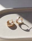 14k gold fill small hoop stud earrings featuring a textured outside band, photographed on a ceramic dish | handmade by Token Jewelry in Eau Claire, Wisconsin