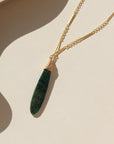 Token Jewelry 14k gold fill Sailor chain necklace with a long green malachite stone, photographed on a ceramic dish