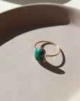 14k gold fill ring with a green malachite stone, photographed on a ceramic dish | handmade by Token Jewelry in Eau Claire, Wisconsin