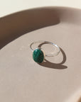 sterling silver ring with a green malachite stone, photographed on a ceramic dish | handmade by Token Jewelry in Eau Claire, Wisconsin
