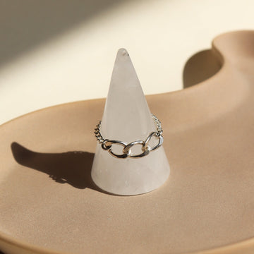 925 Sterling Silver chain ring that features a Alexandra chain along with the la mer chain set on top of a ring holders set on top of a tan ceramic dish