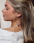 Model wearing 14k gold fill Rainbow Hoops. These rings feature a unique Opal pebble gemstone.