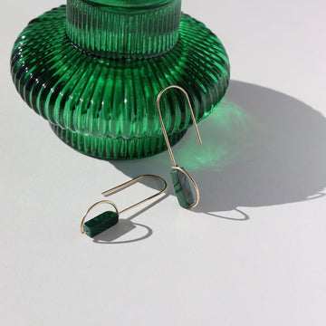 14k gold fill hook drop earrings featuring a malachite tube stone, photographed next to a green glass vase