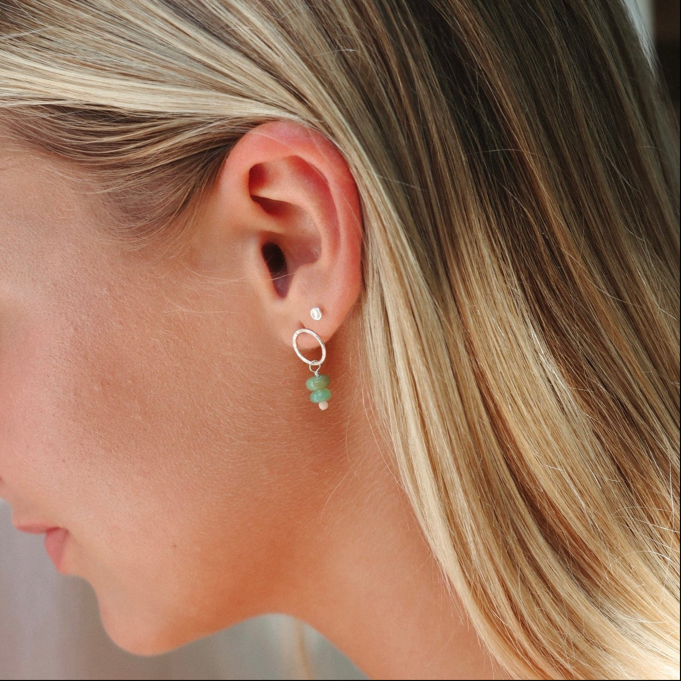 model wearing sterling silver circle studs with opals and coral beads 