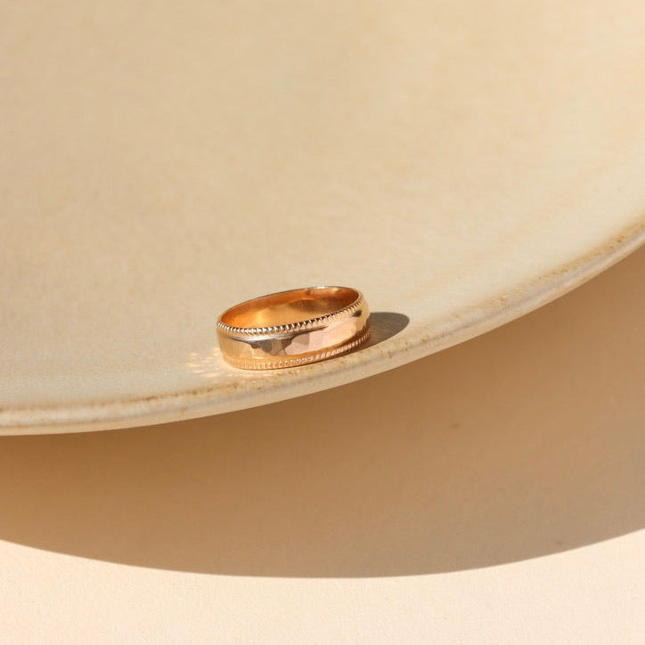 14k gold fill textured band ring on a light dish