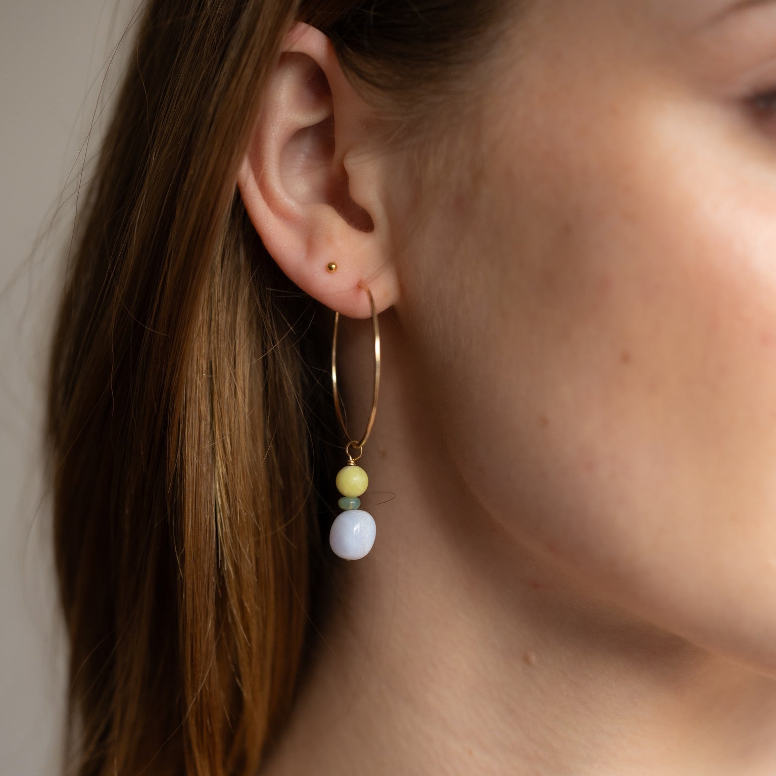 model wearing 14k gold fill hammered hoop earrings with jade and blue lace agate gemstone charms