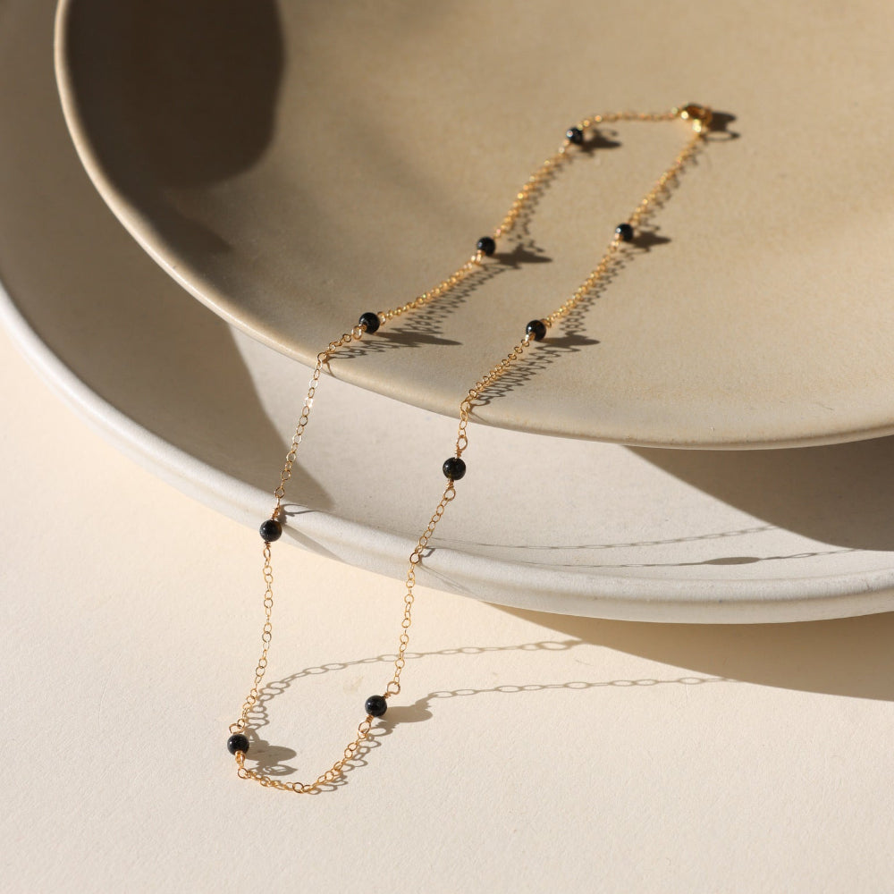 The Lennox Chain features smooth black tourmaline gemstones along a delicate cable chain—crafted in gold fill or sterling silver for balance and protection