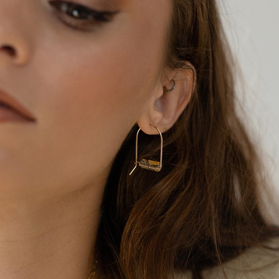model wearing 14k gold fill arch shaped earrings with jasper stones