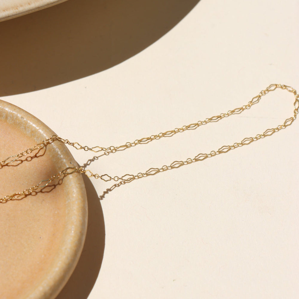 14k gold fill chain necklace on a light dish