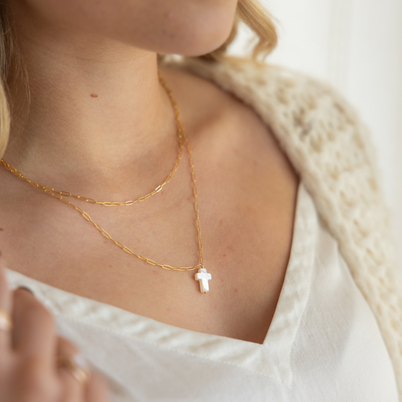 model wearing 14k gold fill paperclip chain necklace with a mother of pearl cross pendant 