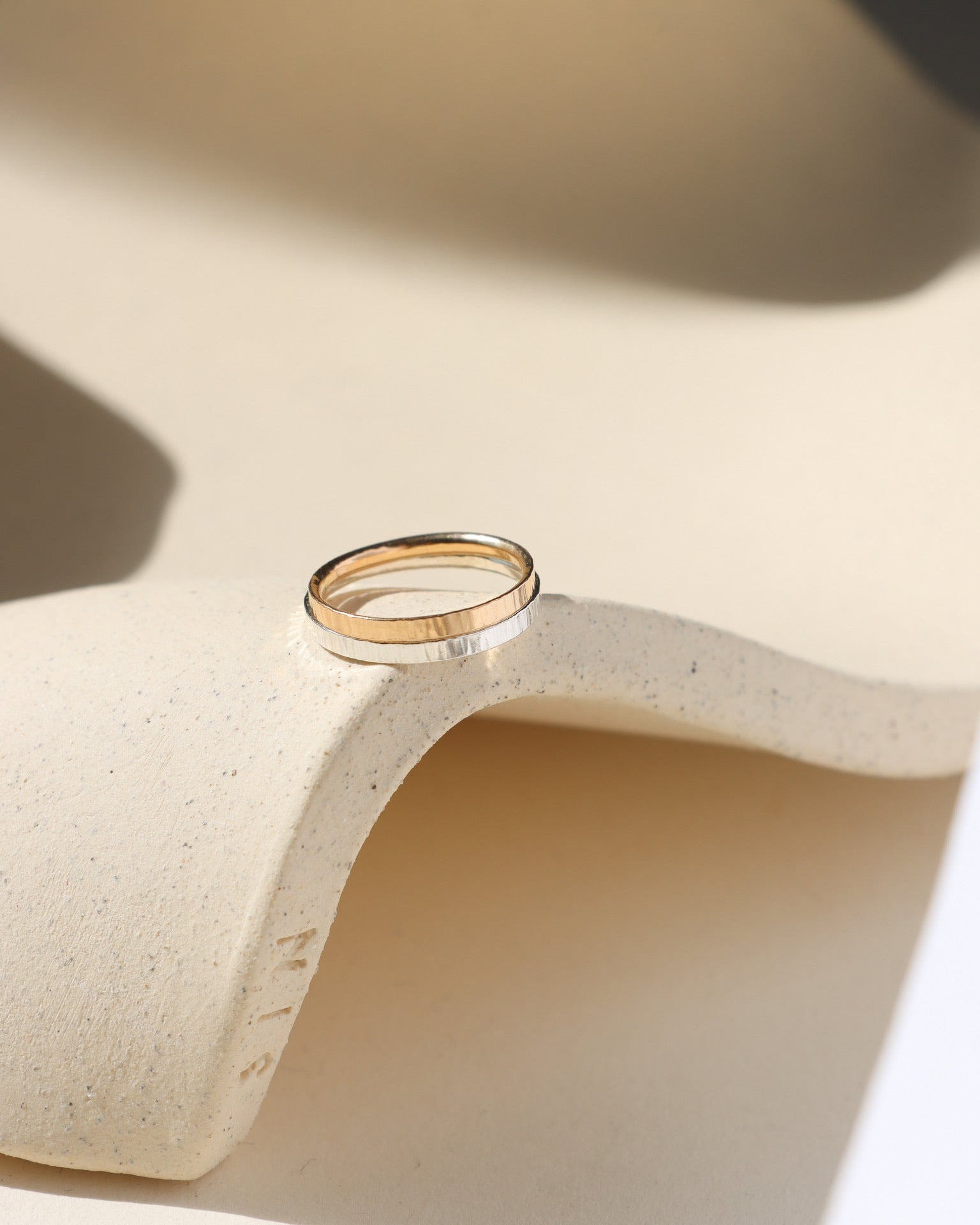 14k gold fill and sterling silver maeve ring stacked together on wavy dish 