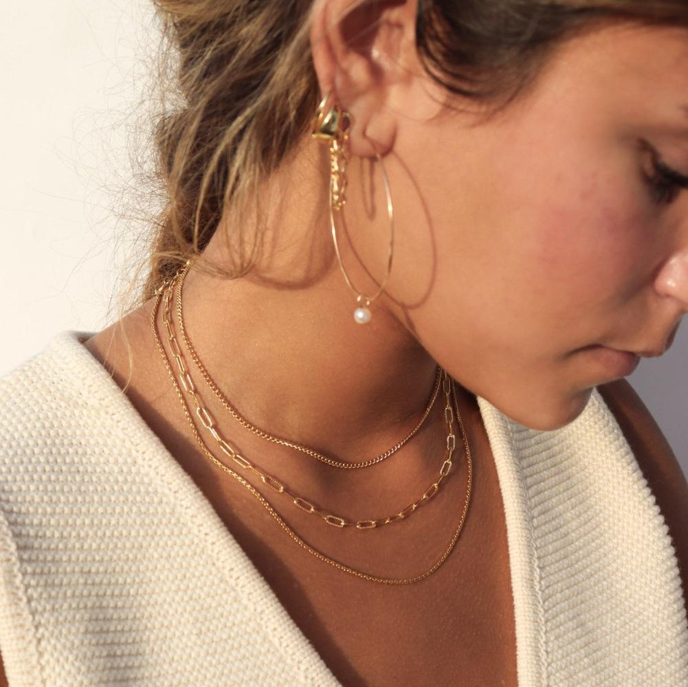 Makara Chain by Token Jewelry in 14k gold fill, photographed on a model wearing a white vest top and other 14k gold fill jewelry
