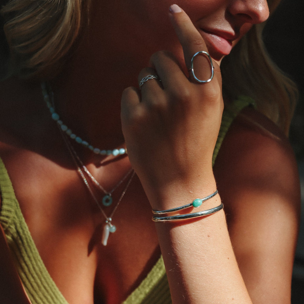 model wearing sterling silver cuff with oval amazonite stone paired with other sterling silver jewelry