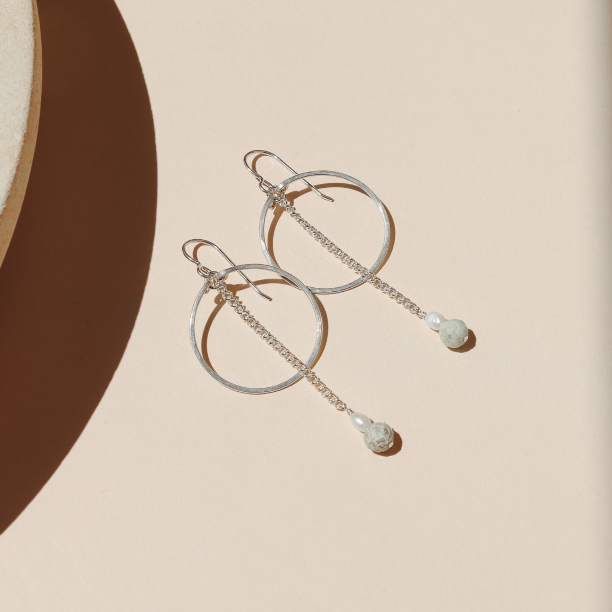 sterling silver hoops with chain, pearl, and turquoise beads in the sunlight