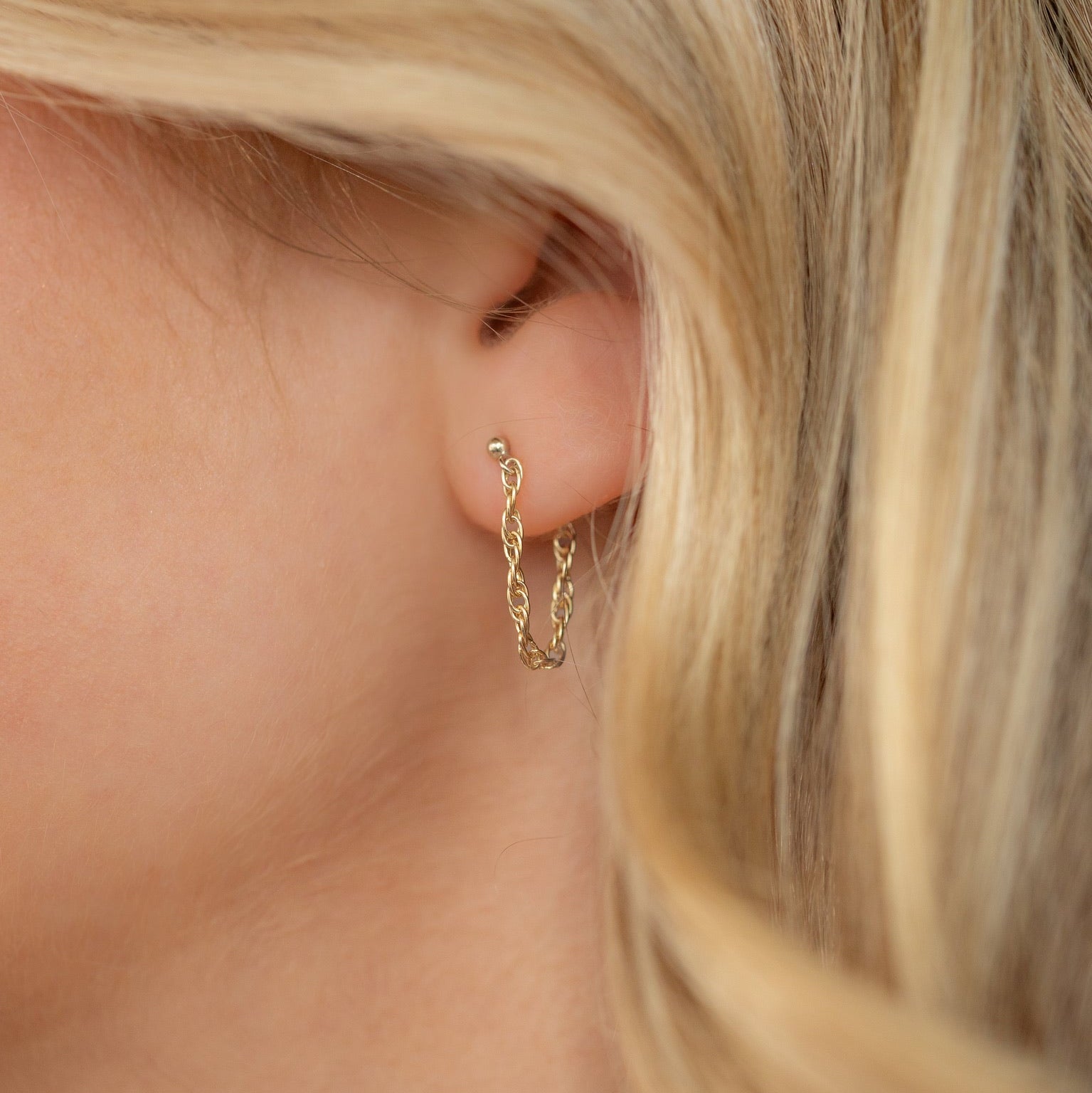 model wearing 14k gold fill chain stud earrings with 14k gold fill hand chain 