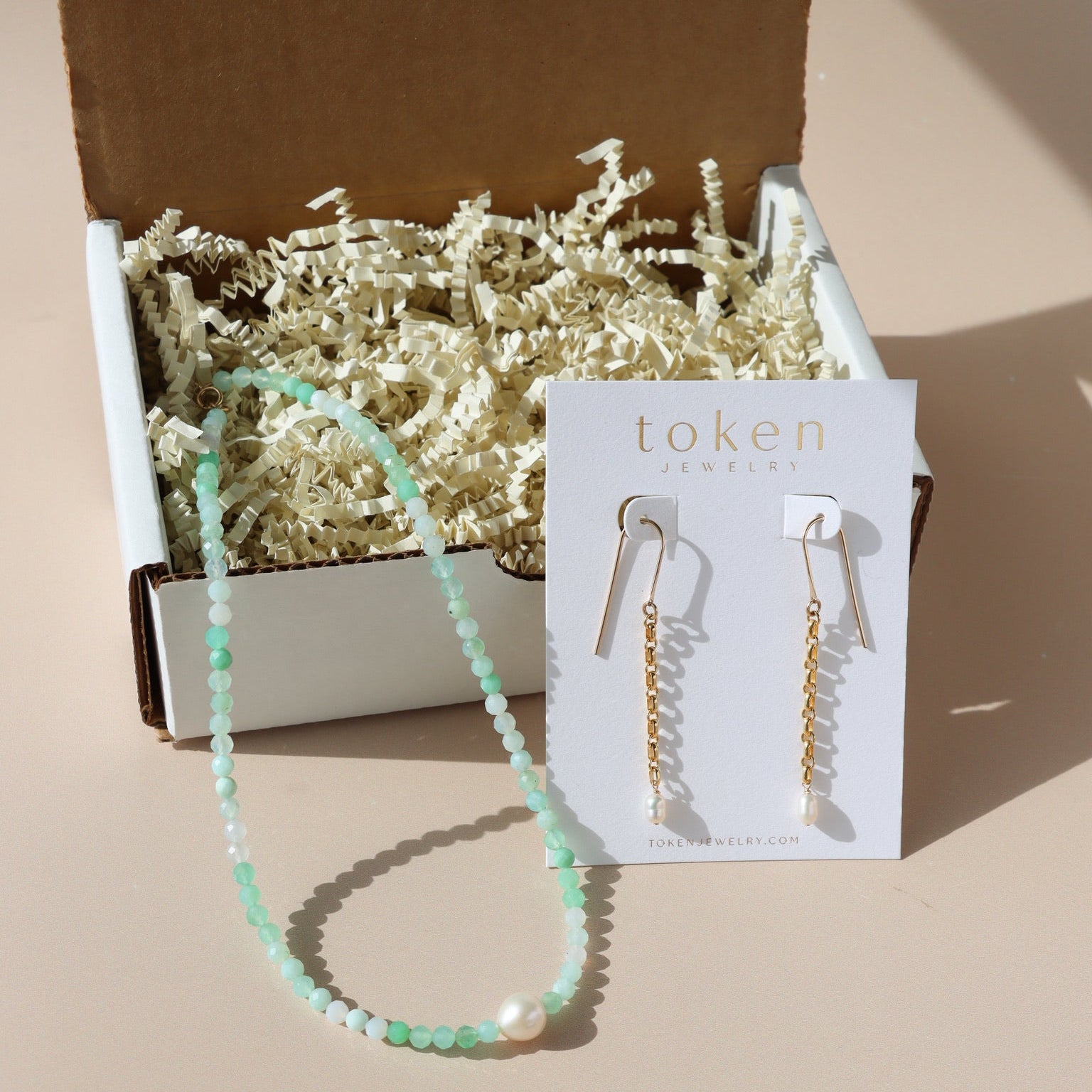 Token Jewelry's mini mystery box featuring a necklace and pair of earrings