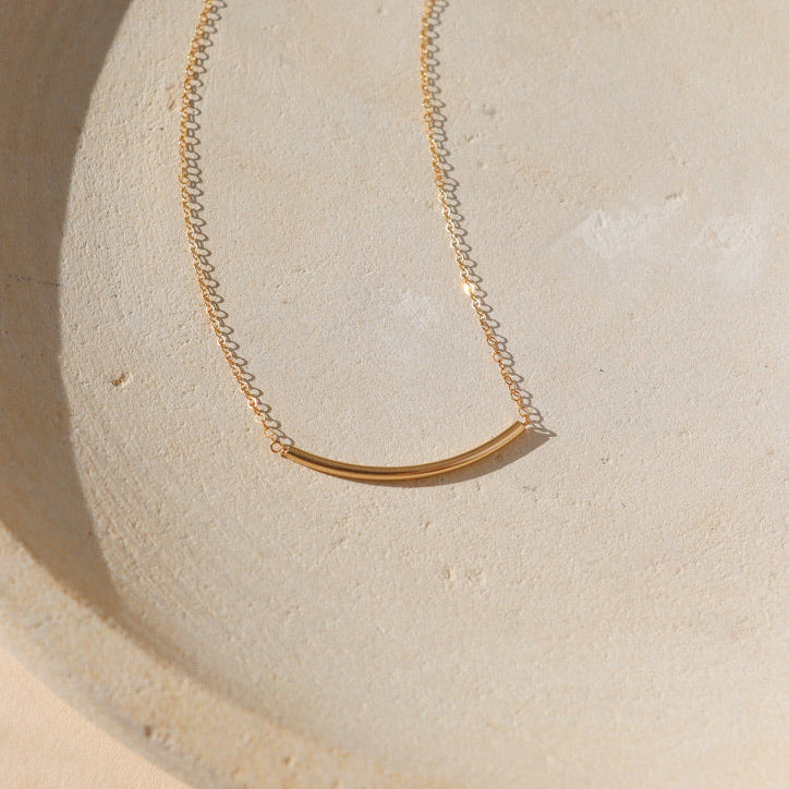 14k gold fill dainty chain with 14k gold fill tube on a light dish