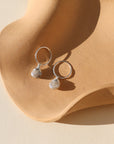 Sterling silver hoop earrings featuring iridescent moonstone charms with soft, shimmering hues.