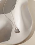 Delicate sterling silver necklace featuring a shimmering oval moonstone pendant with iridescent hues.