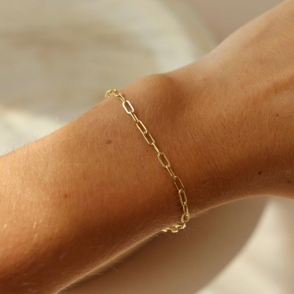model wearing 14k gold fill paperclip chain bracelet
