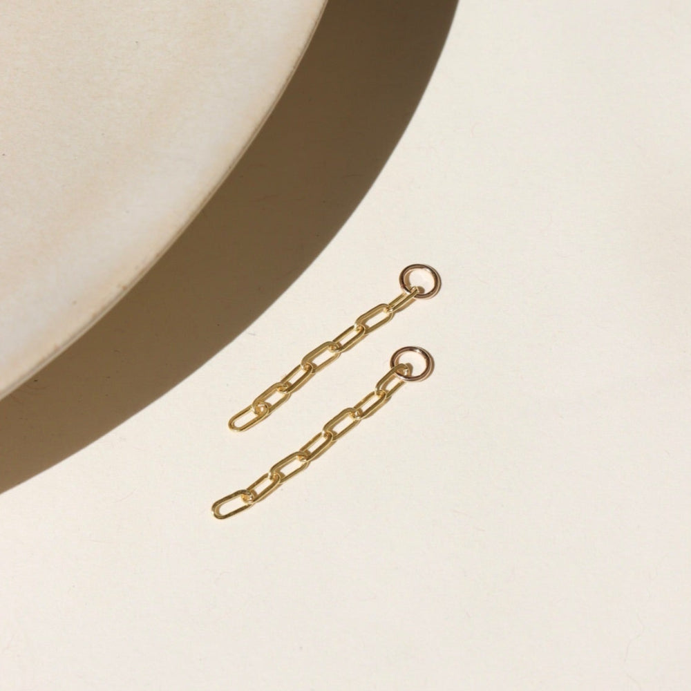 14k gold fill short paperclip chain dropped from a 4mm jump ring, displayed on a cream backdrop in the sunlight 