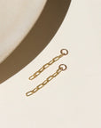 14k gold fill short paperclip chain dropped from a 4mm jump ring, displayed on a cream backdrop in the sunlight 