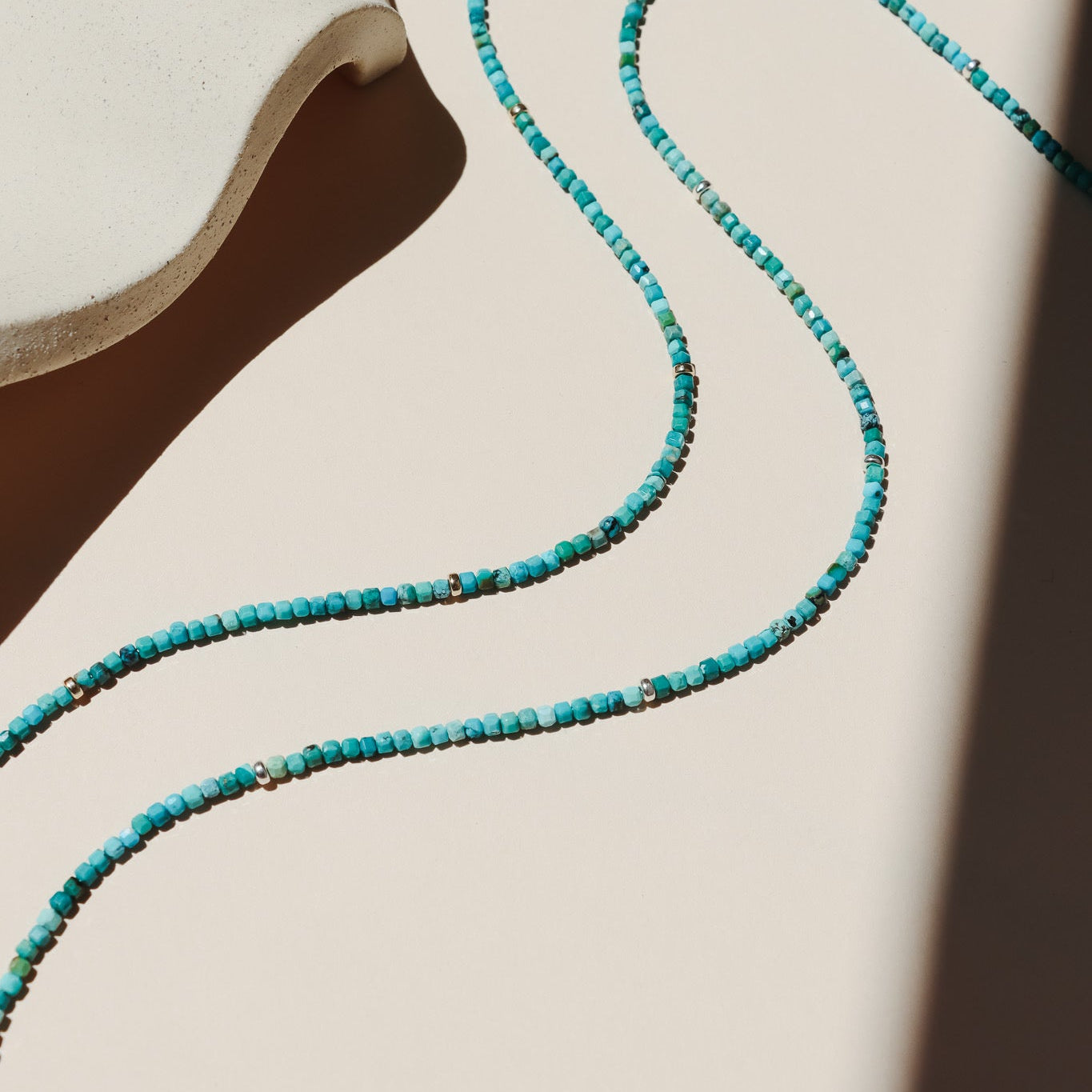 beaded turquoise necklace on a light dish