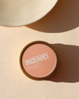 peach colored candle tin on a light background - scent is palisades