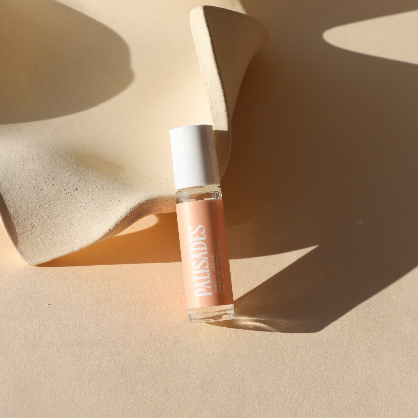 light pink perfume roller bottle in the sunligth - scent Palisades