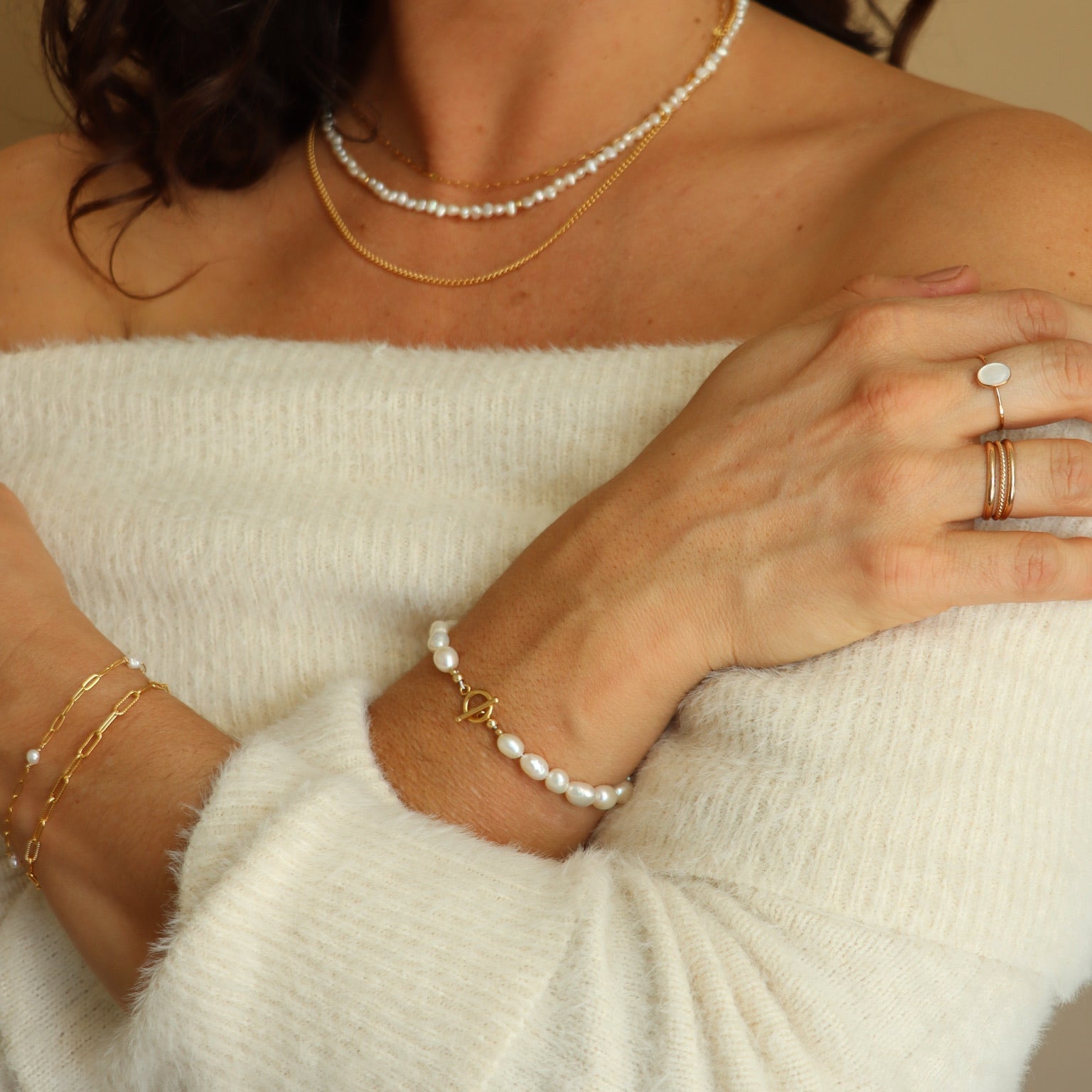 Gold toggle bracelet featuring a strand of lustrous freshwater pearls and a bold circular toggle clasp.