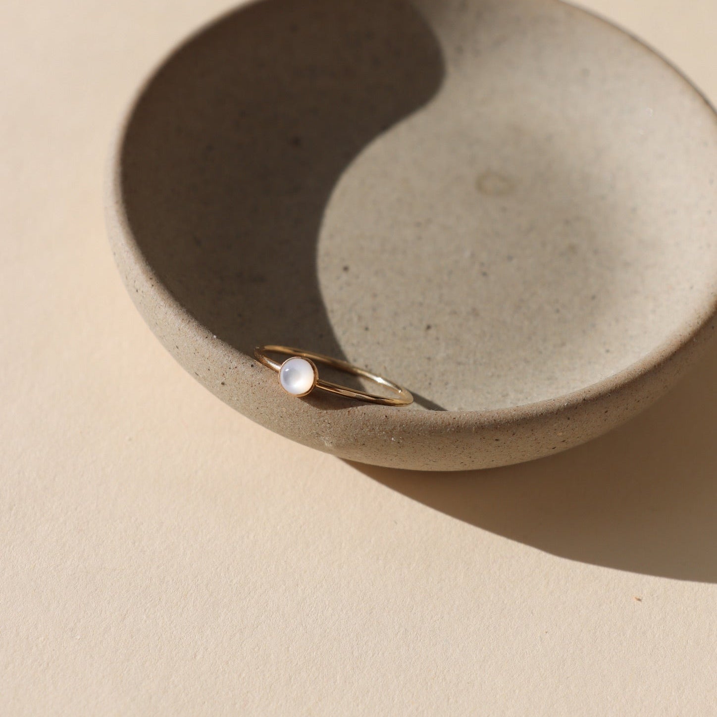14k gold fill bezel ring with 4mm pearl stone in a light dish