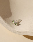sterling silver ear posts with 4mm peridot stones on a light dish