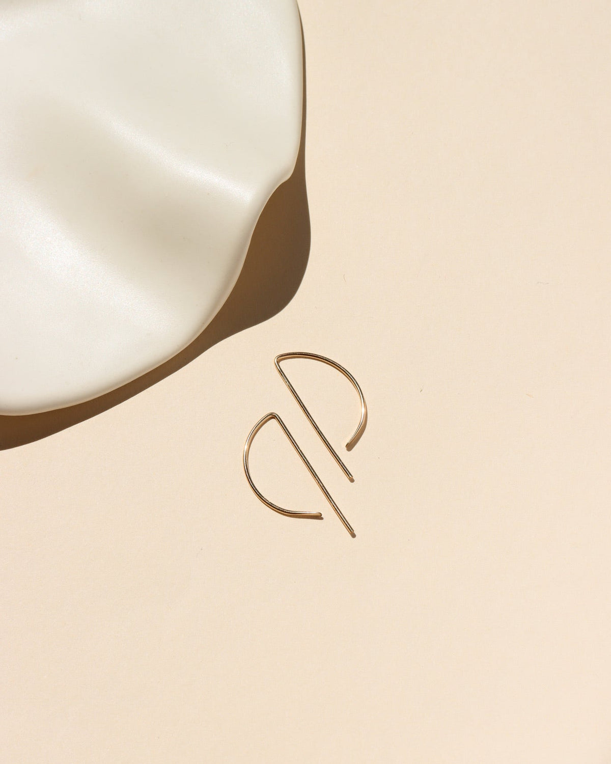 14k gold fill, P shaped threader earrings displayed on a cream backdrop 