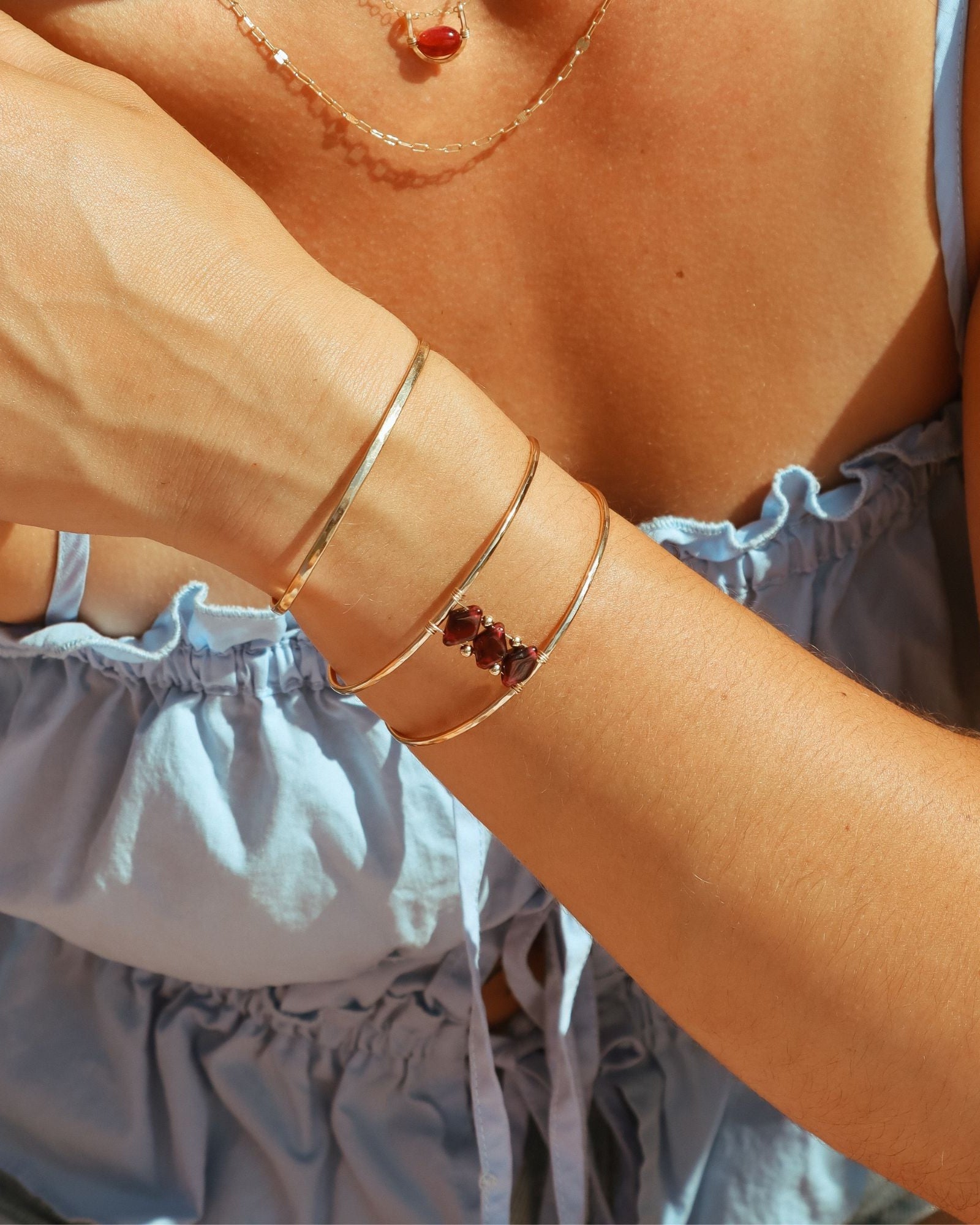model wearing 14k gold fill cuff with rubies and ruby necklaces