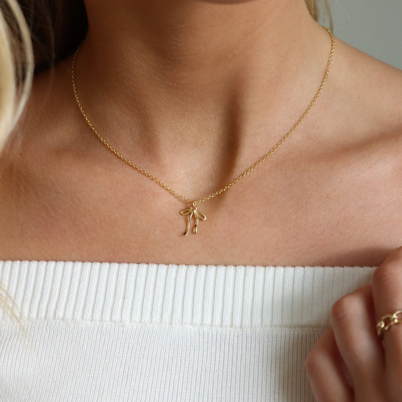 Delicate gold ribbon necklace with a minimalist bow design