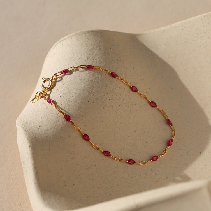 ruby enamel chain link with 14k gold fill chain on a wavy plate in the sunlight