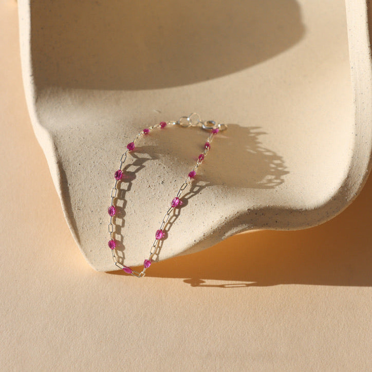 sterling silver chain with transparent ruby gemstones on a dish 