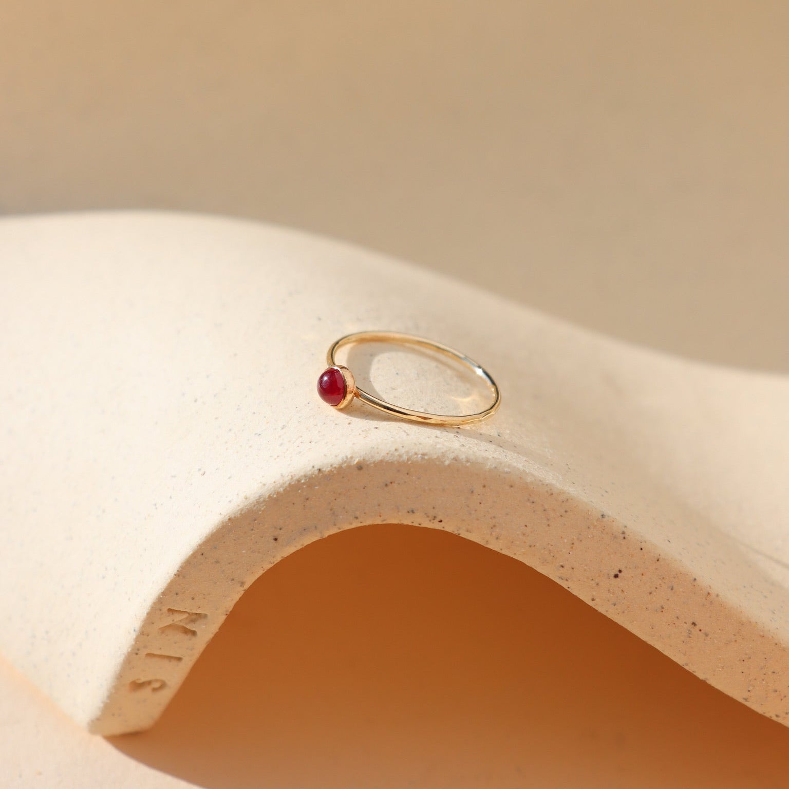 4mm ruby stone set in a 14k gold fill ring setting in the sunlight