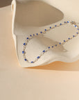sterling silver chain bracelet with sapphire gemstones on a light dish in the sunlight