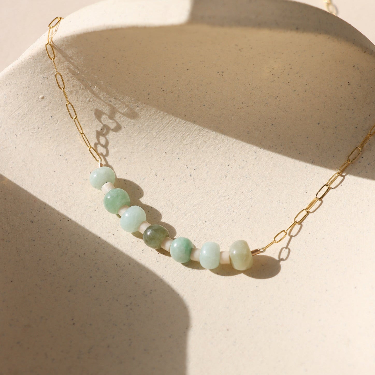 14k gold fill chain necklace with jade and jasper beads on a light background