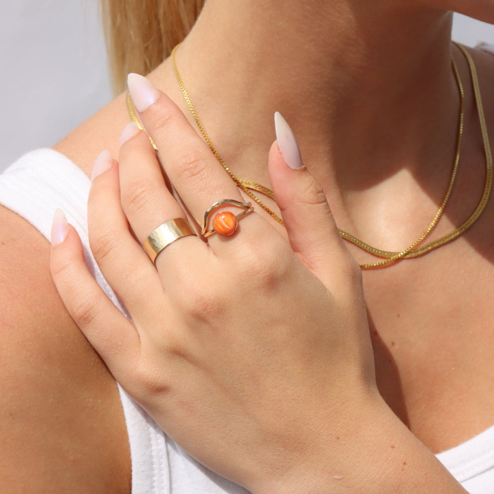 Model wearing Sienna Ring featuring a vibrant spiny oyster gemstone on a hand-hammered gold filled band.
