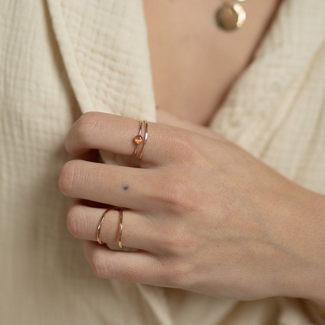 model wearing 14k gold fill skinny ring styled with tiny gemstone ring and infinity ring