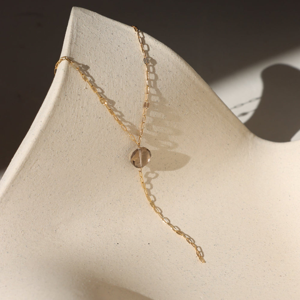 Delicate gold lariat necklace featuring a smooth smoky quartz pendant on the Sunspell chain, handcrafted for a warm, minimal look.