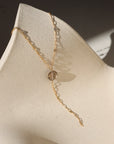 Delicate gold lariat necklace featuring a smooth smoky quartz pendant on the Sunspell chain, handcrafted for a warm, minimal look.