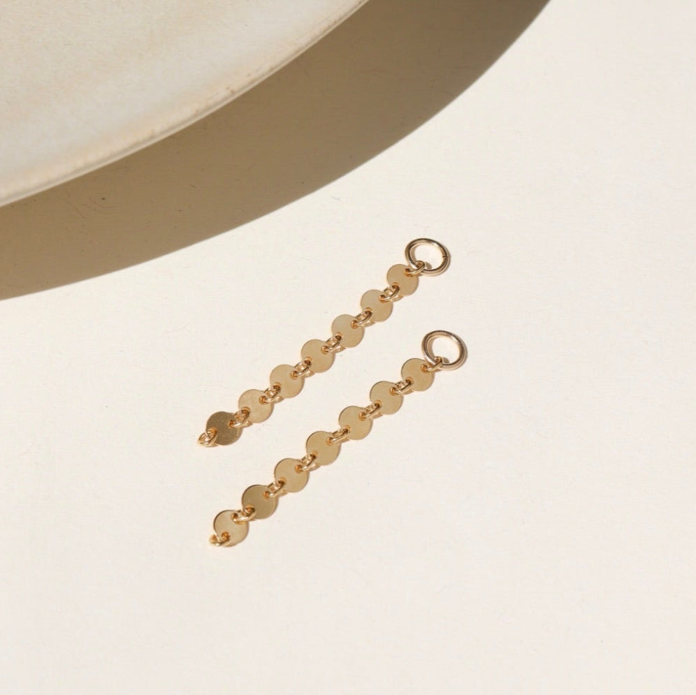 14k gold fill connectors featuring a short circle chain, dropped from a 4mm jump ring, displayed on a cream back drop in the sunlight 